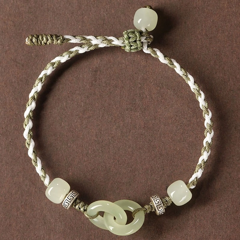 Top-down view of hetian jade peace buckle braided bracelet showing interlocking buckles and metal spacers