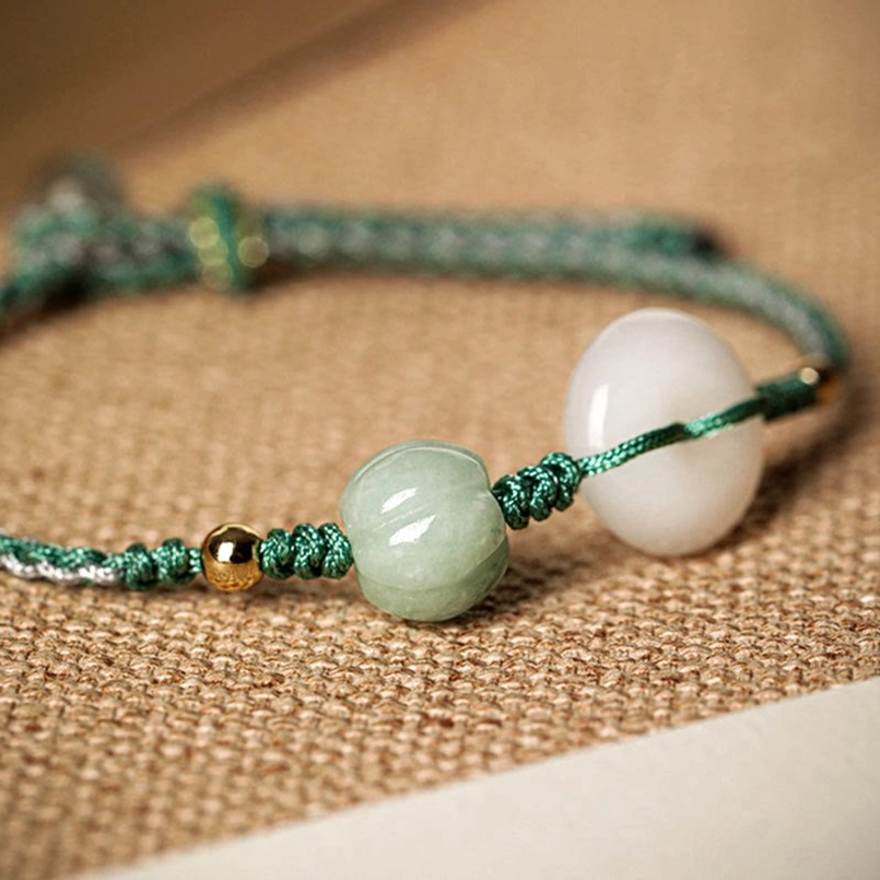 White jade peace buckle bracelet with round green jade bead side view on burlap