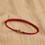999 gold peace buckle red string bracelet top view with braided cord and gold charm