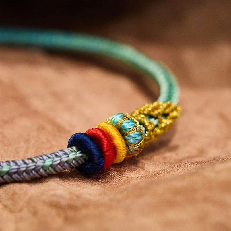 Close-up detail of eight thread peace knot with gold woven wrap and colorful decorative knots