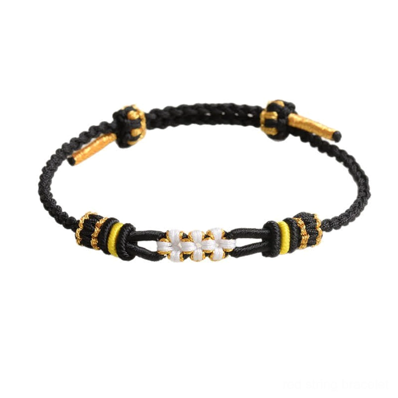 Black handmade peach blossom luck bracelet with white flower knot gold and black accent beads overhead view