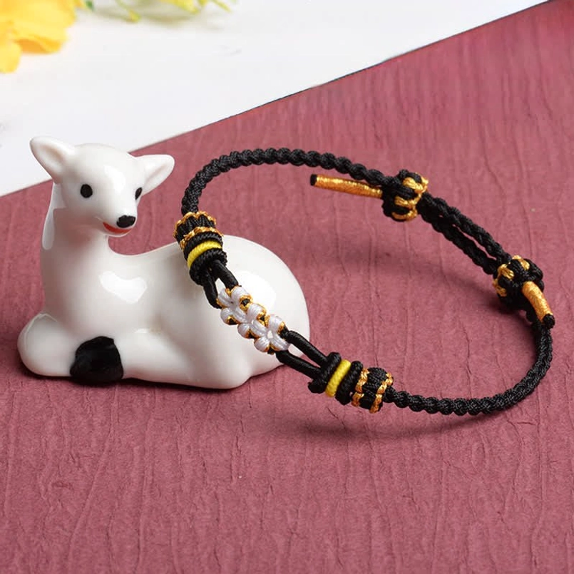 Black braided peach blossom bracelet with multicolor woven metal decorative details and white deer figurine