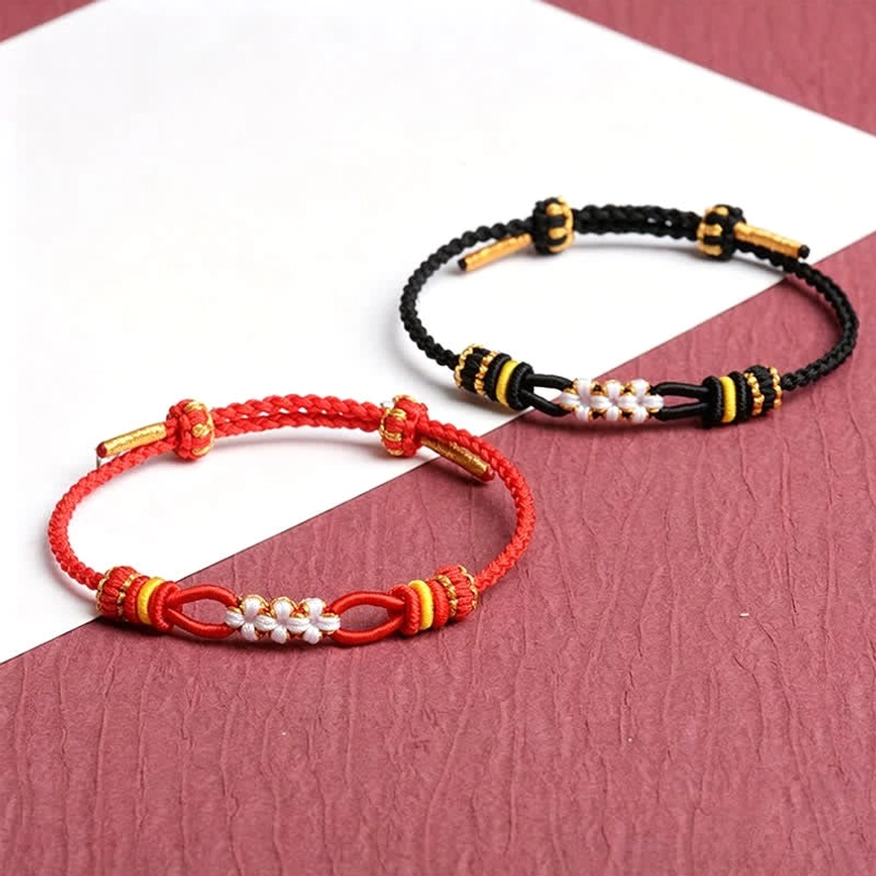 Two assorted handmade peach blossom luck bracelets red and black with matching decorative knot sets