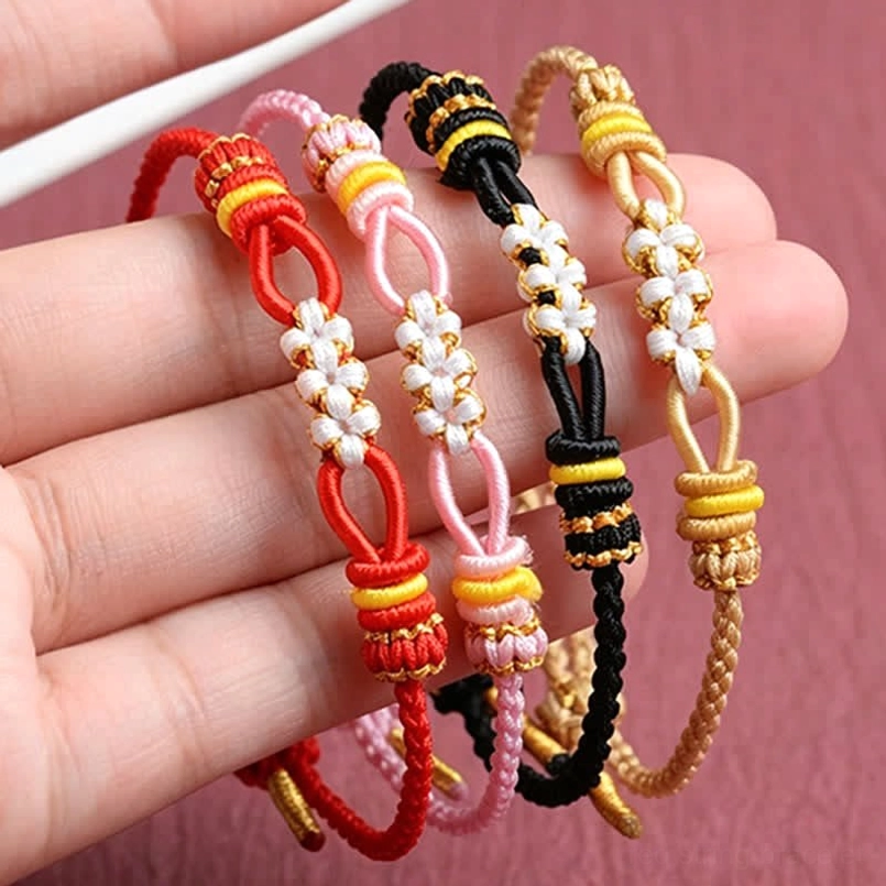Multiple handmade peach blossom luck bracelets on fingers lifestyle wearing display mixed colors