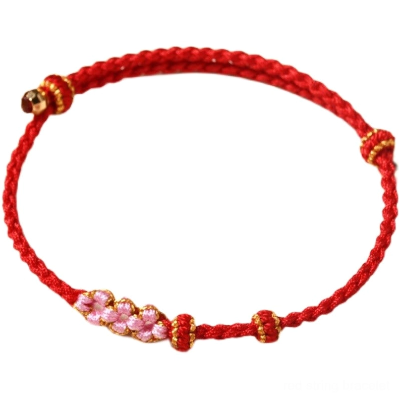 Full peach blossom protection red string bracelet with gold hardware flat lay