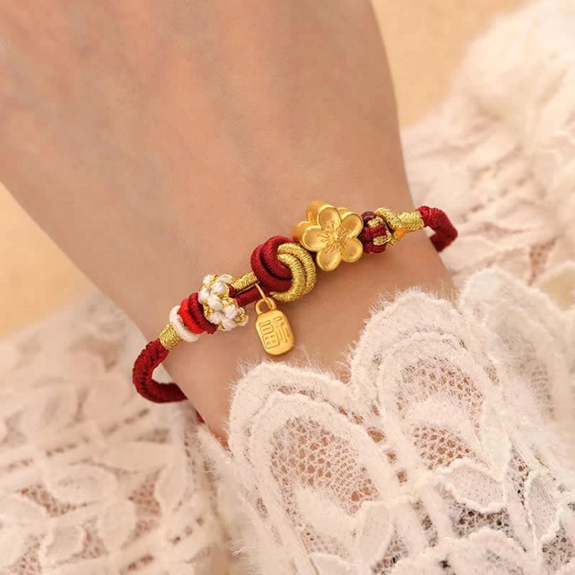 Close-up side view of lucky peach blossom red string bracelet on wrist with lace background