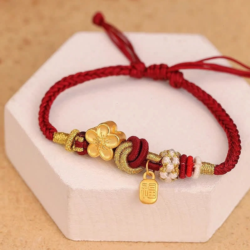 Peach blossom red string bracelet flat lay on white display block showing adjustable design