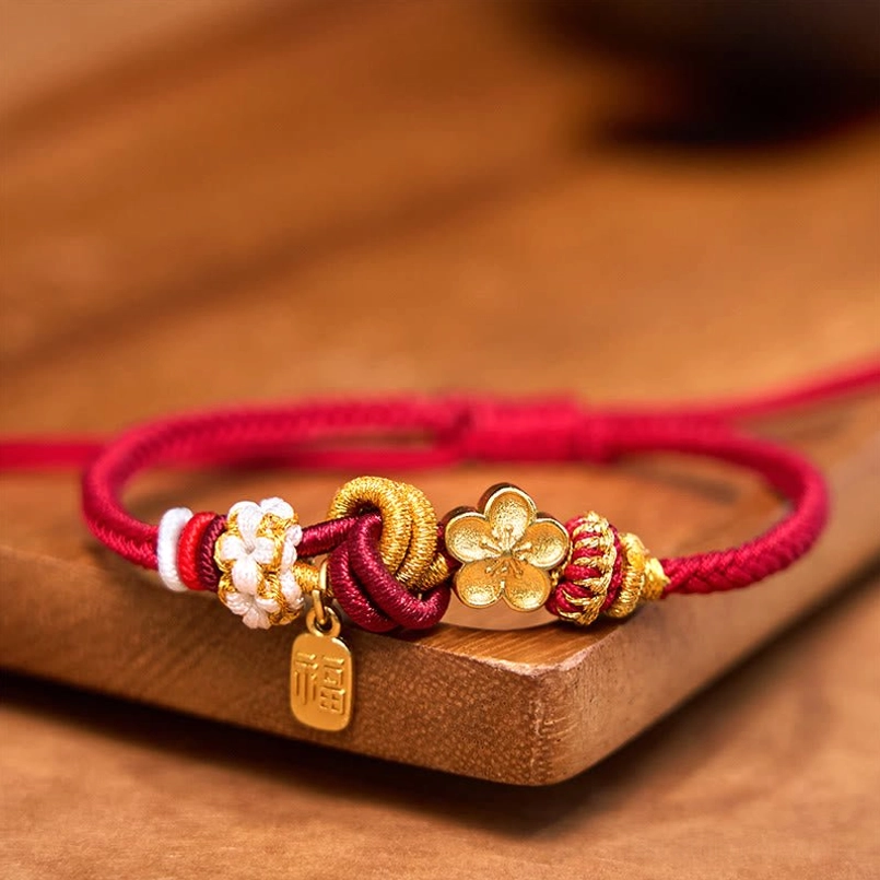 Top view of peach blossom fortune red string bracelet with braided cord and bead accents