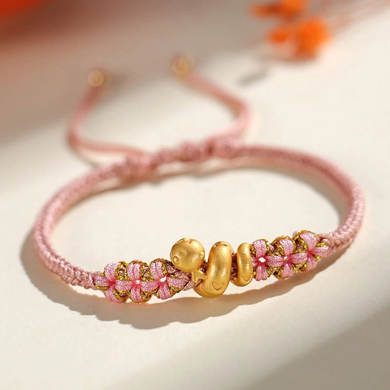 Close up of pink woven peach blossom accent on snake luck bracelet