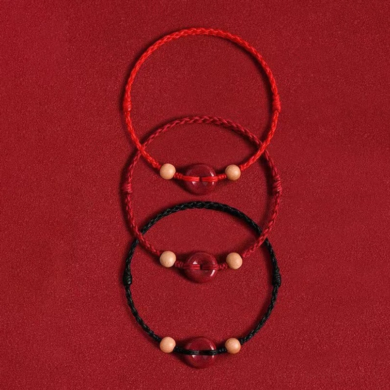 Collection of red and black rope peach wood bracelet variants stacked display