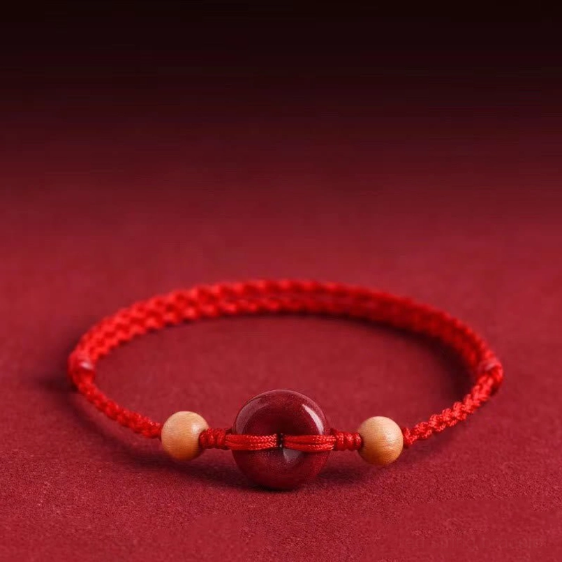 Cinnabar peace buckle red braided bracelet centered flat lay product shot