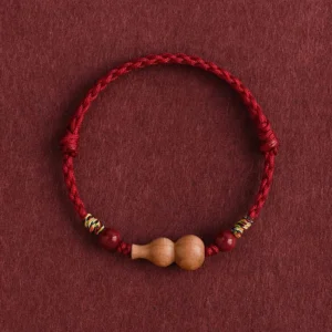 Peach wood gourd red string bracelet with cinnabar beads and colorful woven accents, full top-down view