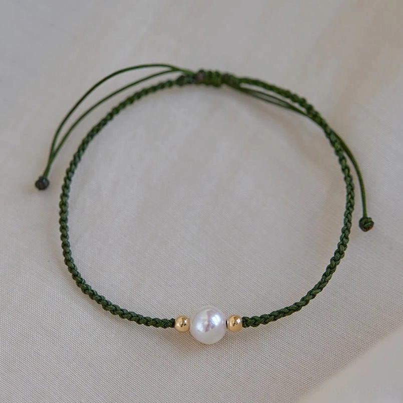 Pearl red string bracelet product lifestyle wear with casual dark clothing background