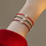 Pearl red string bracelet multicolor strands overhead wrist view natural pearls gold beads