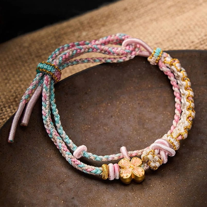 Pastel pink and blue double layer woven bracelet with gold flower charm