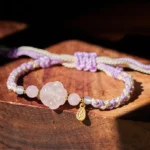 Pink Crystal Cat Paw Braided String Bracelet main view on wooden table