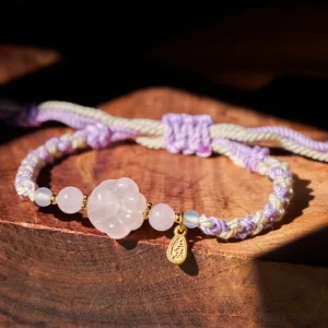 Pink Crystal Cat Paw Braided String Bracelet main view on wooden table