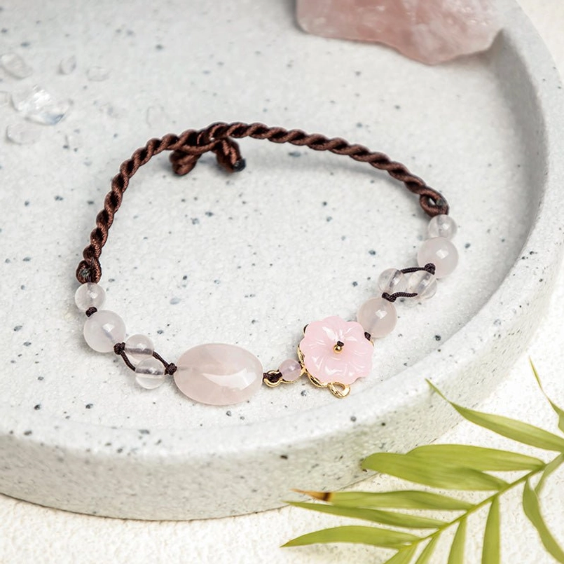 Pink crystal anklet on ceramic tray with natural elements and raw crystals