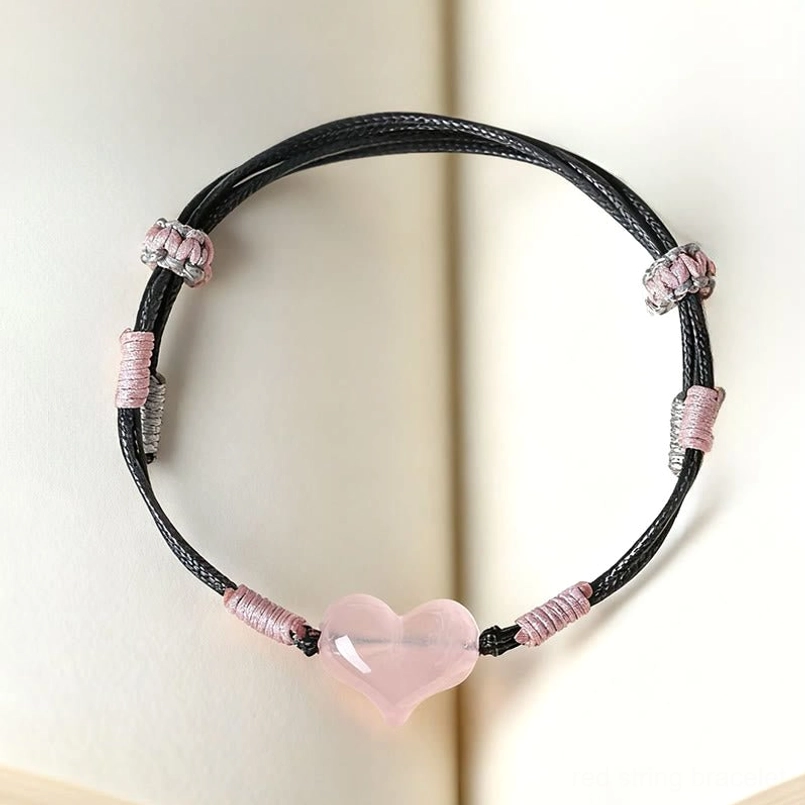 Handmade pink crystal heart bracelet on book background