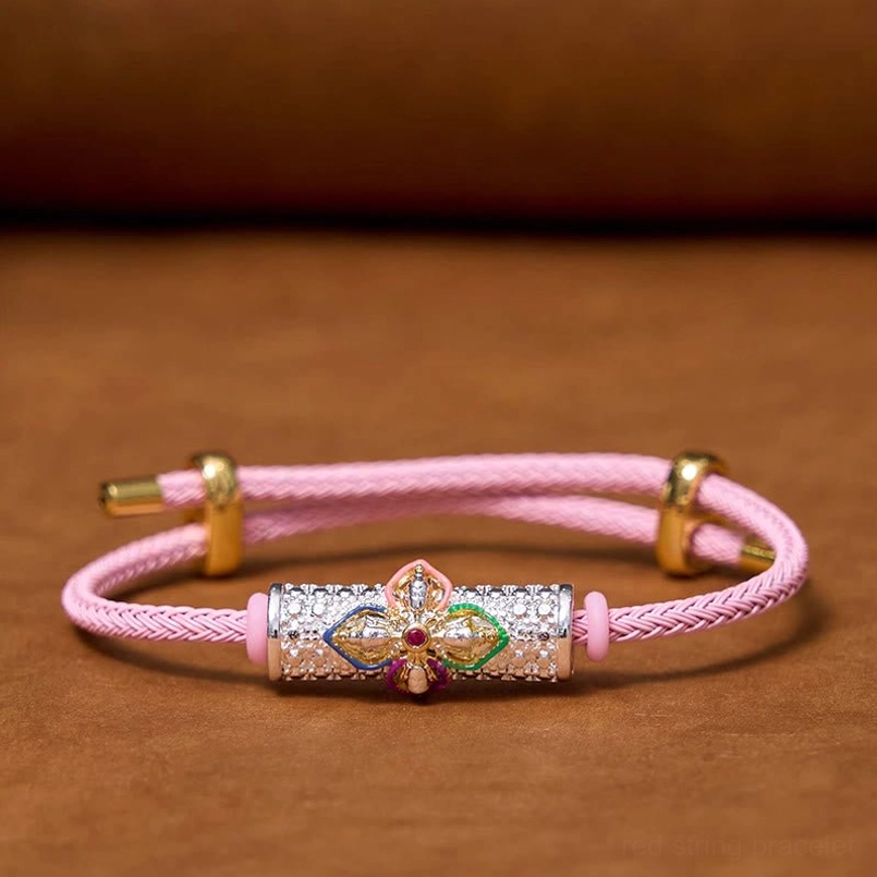 Pink string luck bracelet with detailed enamel flower and silver metal accents