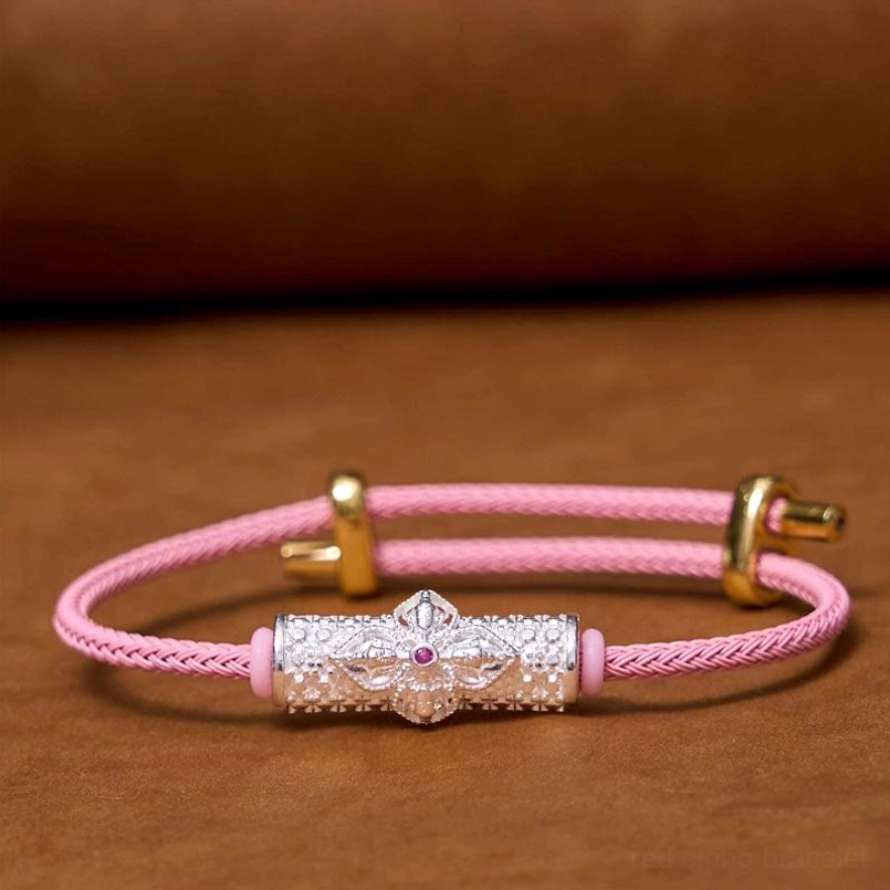 Pink string luck bracelet with ornate copper flower charm and precious metals