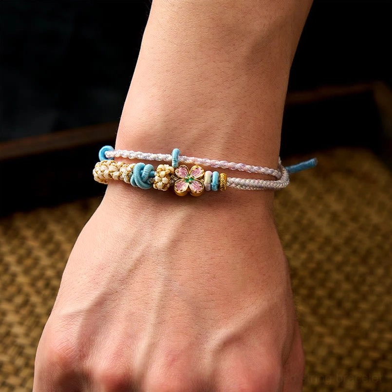 Pink woven string bracelet with peach blossom charm handmade detail
