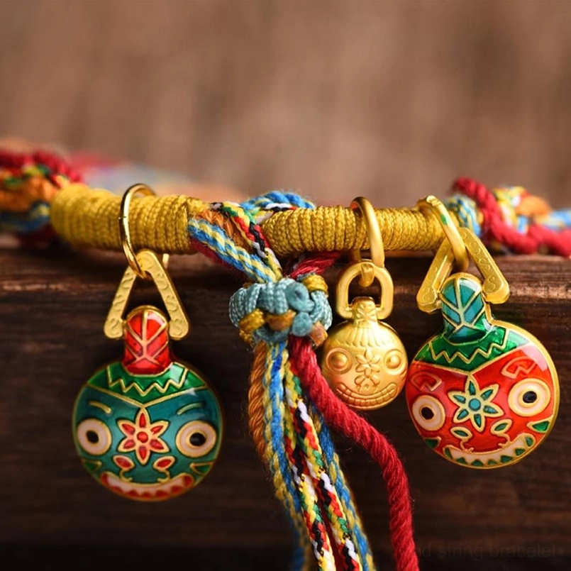 Close-up of gold pixiu enamel charms and metal clasps on family blessing bracelet