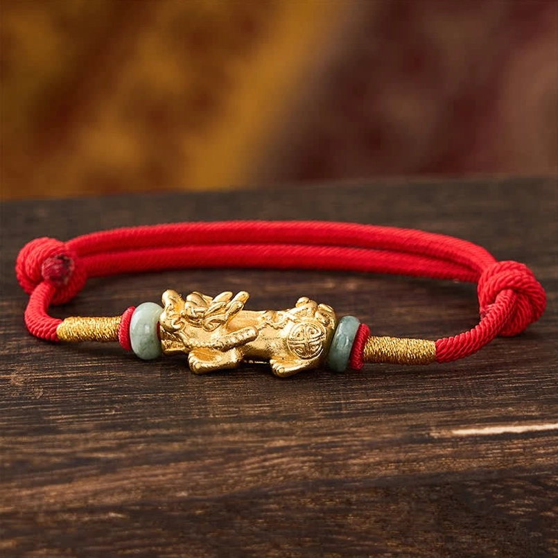 Front view of copper pi xiu charm with polished embossed detailing and jade bead spacers
