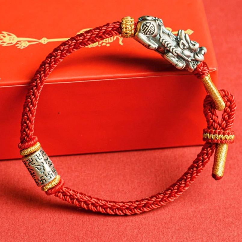 Pixiu mantra bracelet resting on red gift box featuring engraved om mani padme hum silver bead and charm