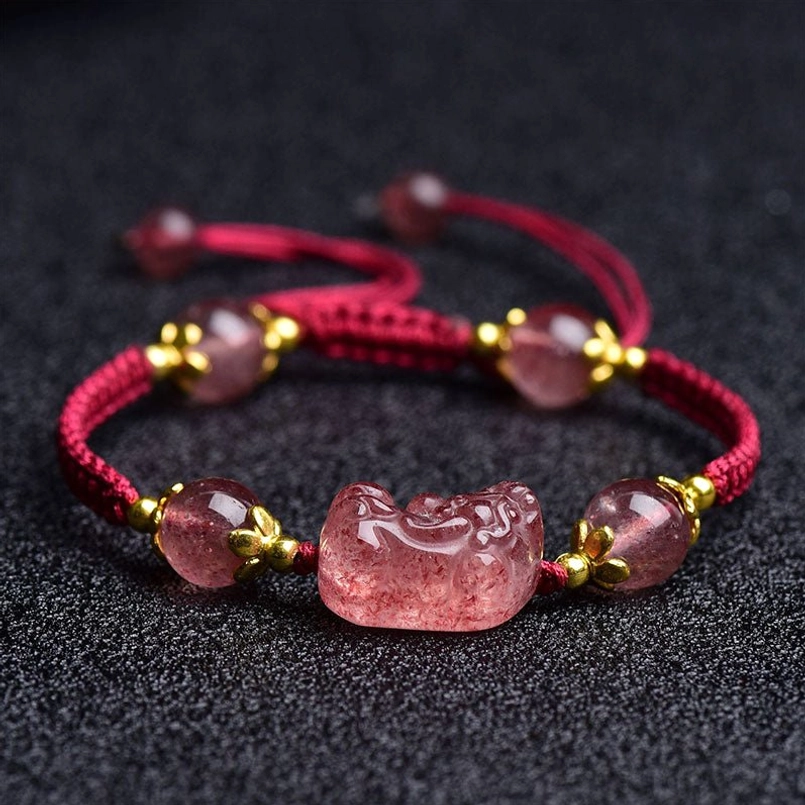 Adjustable red string bracelet with Pixiu charm and strawberry quartz beads flat lay