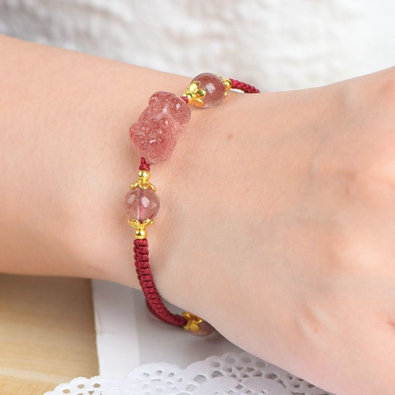 Woman wearing strawberry quartz Pixiu red string bracelet on wrist