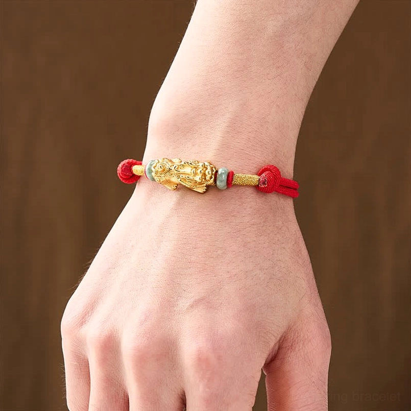 Pi xiu red string bracelet worn on wrist showing jade beads and knotted cord closure