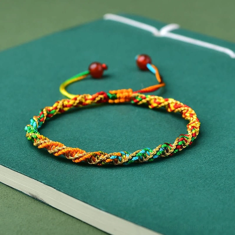Plain multicolor twisted rope festival bracelet without charm pendant on green background