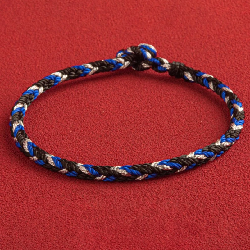 Red string bracelet on wrist showing comfort fit and multicolor design in lifestyle context