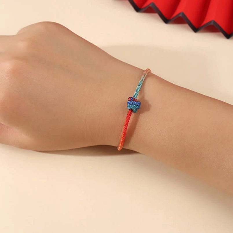 Close-up of hand-woven bracelet on wrist with gradient teal rope and decorative sliding knot