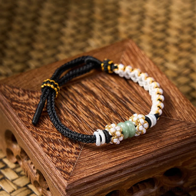 Purple string luck bracelet showing adjustable cord and jade stone accents