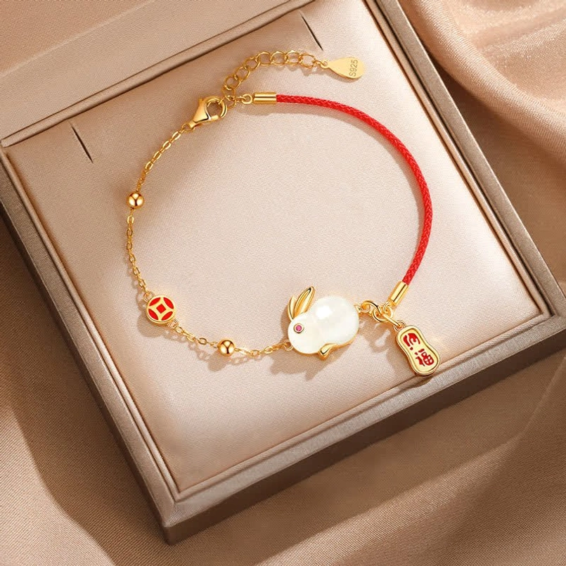 Rabbit red string bracelet flat lay with gift box and satin fabric