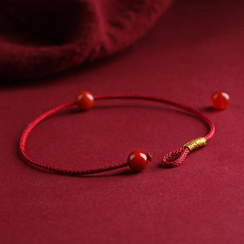 Handmade red agate protection bracelet worn on wrist with woven red string