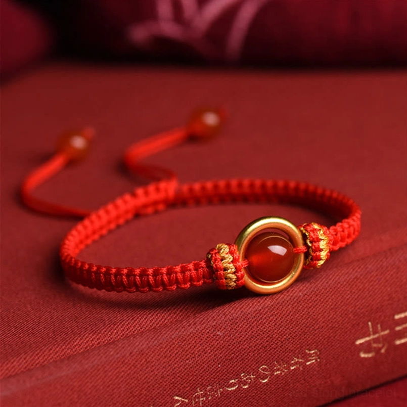 Red Agate Peace Buckle Bracelet Side View With Adjustable Pull Knot On Vintage Book