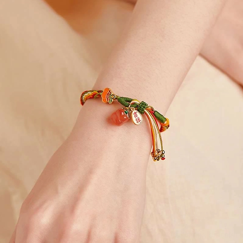Red agate protection bracelet worn on wrist showing multicolor braided rope and tassel