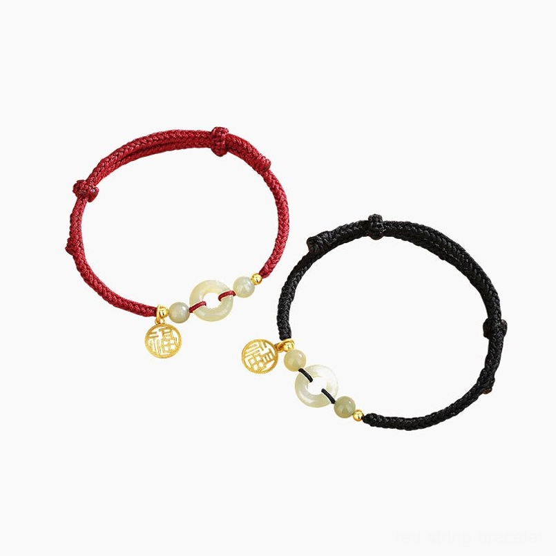 Full view of red and black Hetian jade couple bracelets on light beige background