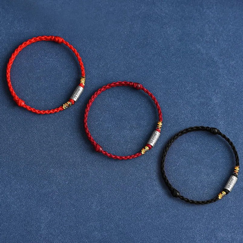 Three lucky bracelets in red and black with sterling silver charms flat lay top view