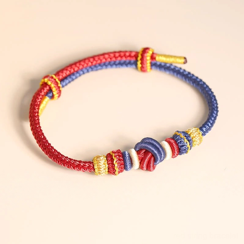 Handcrafted two-color red and blue peace knot bracelet overhead flat lay with adjustable tail detail