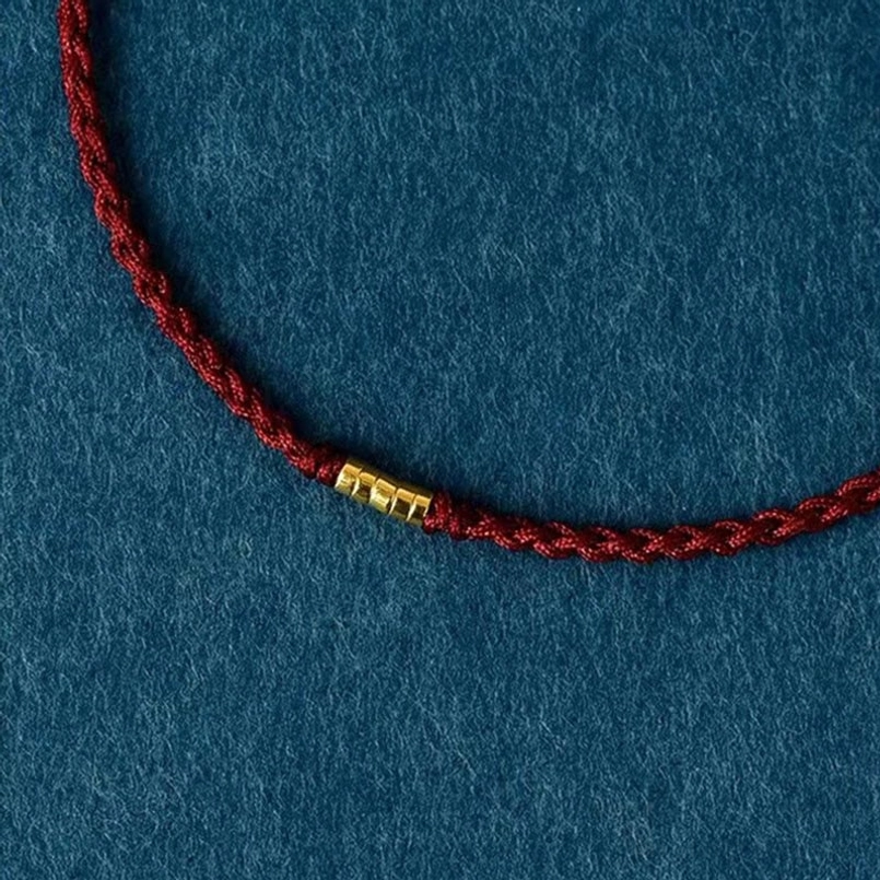 Red braided string bracelet with adjustable sliding knot mechanism