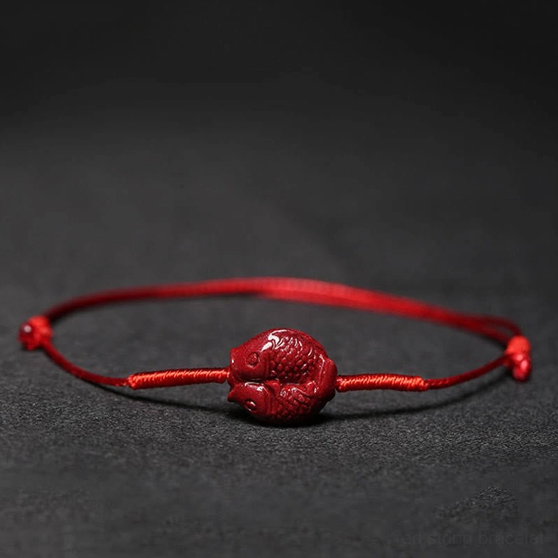 Red cord blessing bracelet with koi fish charm worn on wrist
