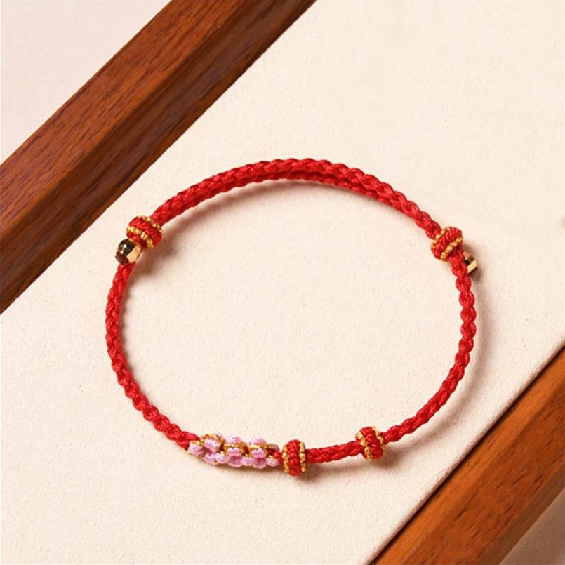 Slim red floral braided bracelet with delicate peach blossom beads and gold knots