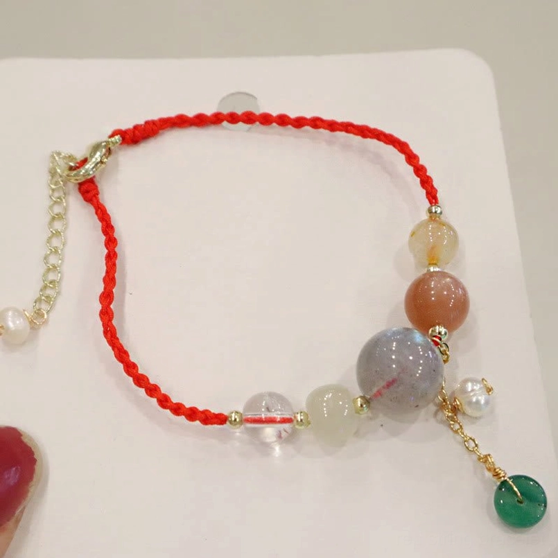 Red braided cord moonstone beaded bracelet with gold extender chain and pearl charm close-up