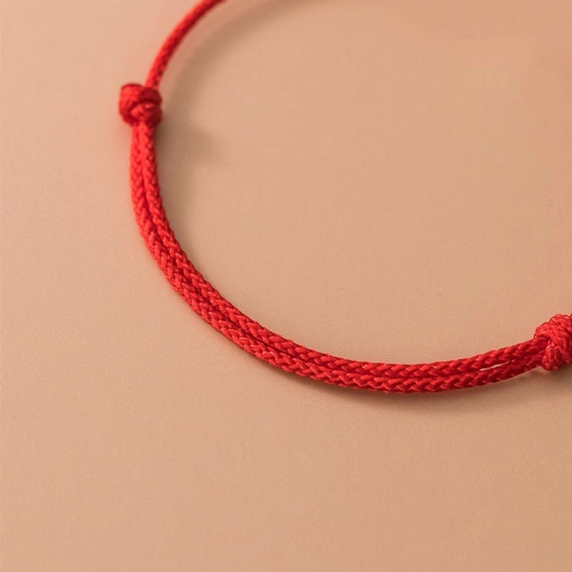 close-up of braided red rope cord with decorative knots on handmade red string bracelet