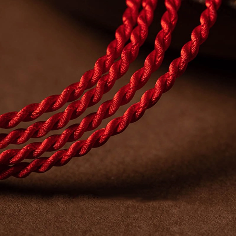 Macro texture shot of twisted red braided rope used in cinnabar belly chain - crimson color detail