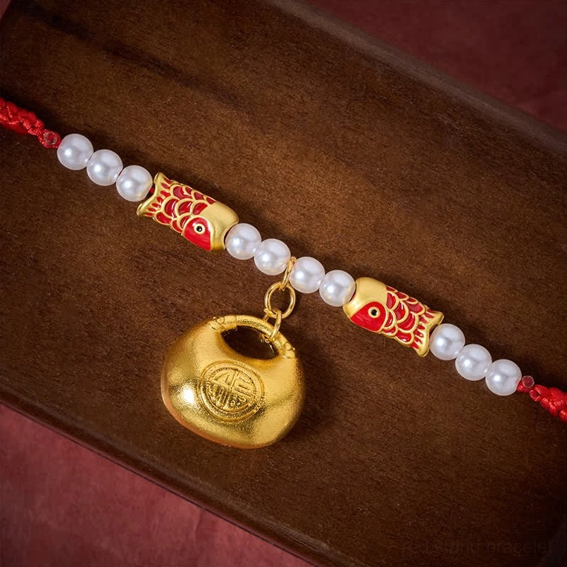 Close-up detail of red braided collar showing koi fish beads, pearls, and engraved Fu pendant